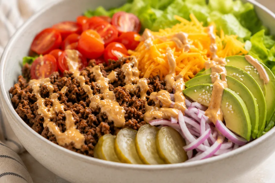 Seasoned ground beef browning in a skillet for burger bowls