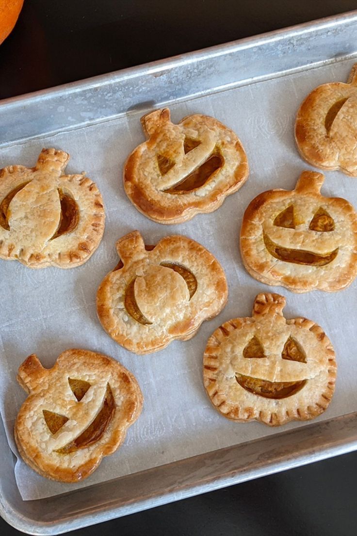 Pumpkin Pies with Carved Faces on a Baking Tray