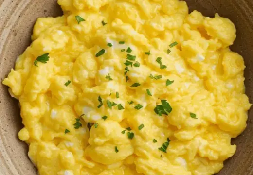 scrambled eggs in a bowl with parsley